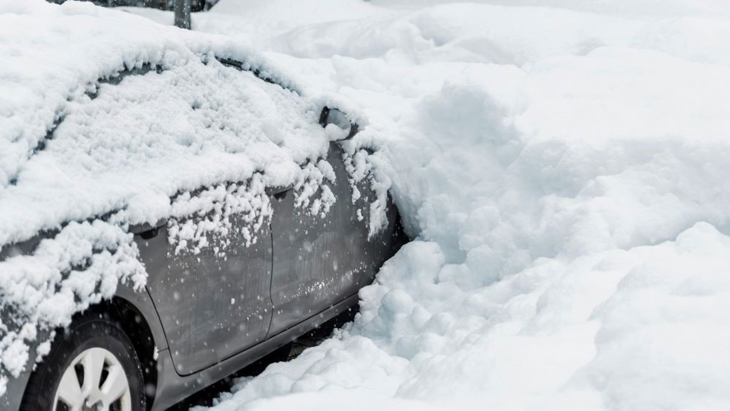 Bildet viser en bil som er begravd i snø. 