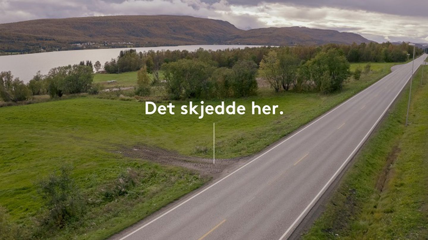 Bilde av en asfaltert vei med en grusvei som kommer inn. Ned mot grusveien er det lagt inn en pil fra teksten "det skjedde her", slik at det vises at det var ved grusveien traktorulykken har skjedd. Foto.