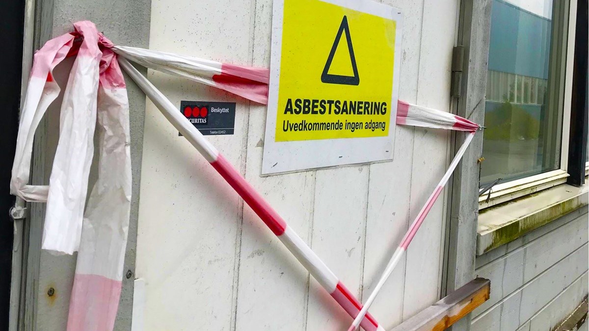 Bildet viser ei dør som det er rødt og hvitt sperrebånd foran. på en gul plakat, står det "Asbestsanering - Uvedkommende ingen adgang". 